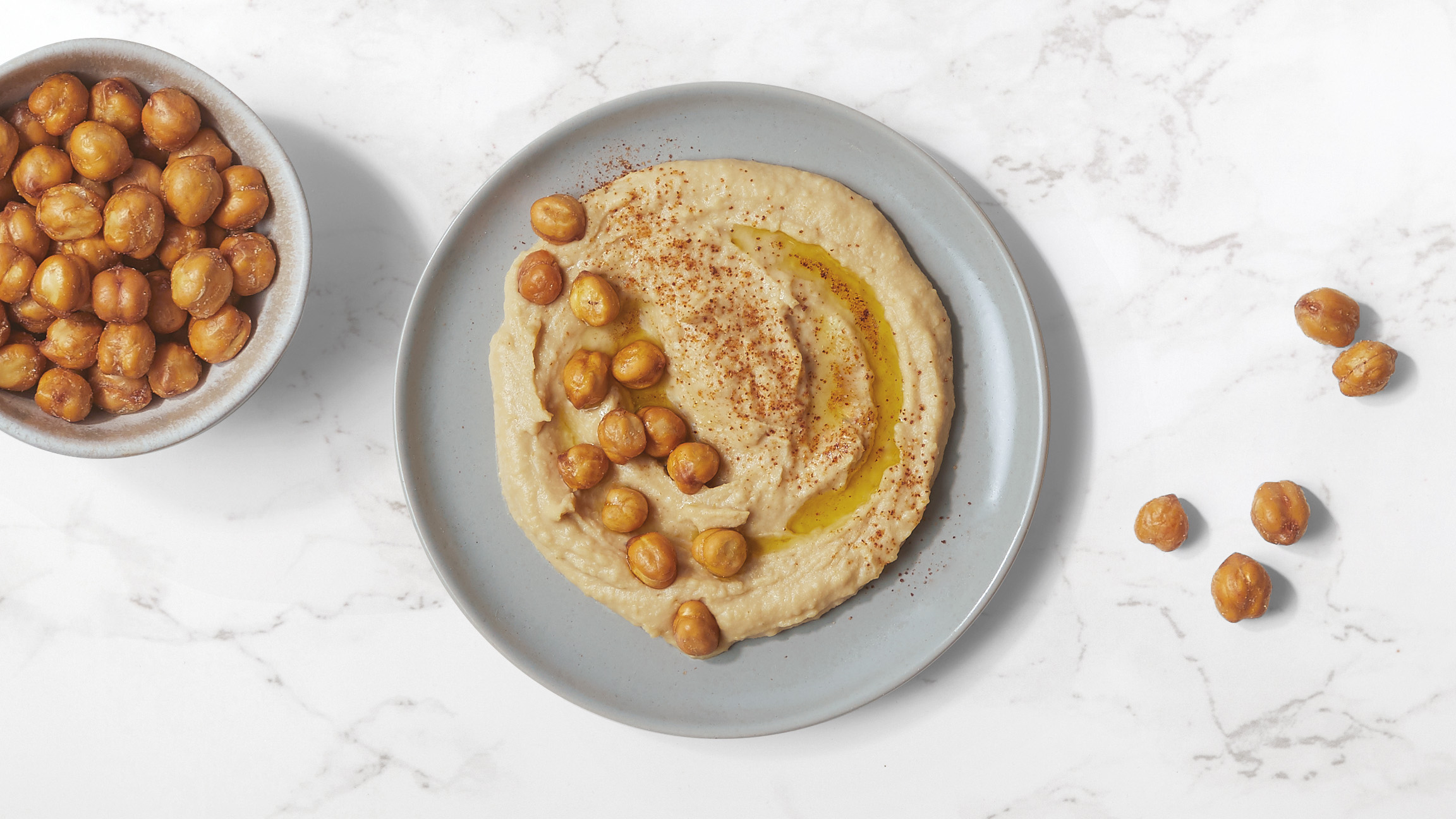 Dish of Roasted & Salted Chickpeas in Hummus with a drizzle of oil and paprika